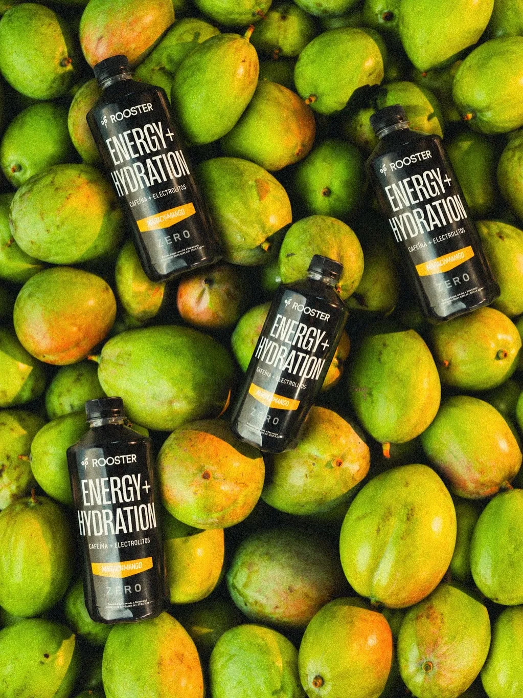 Botellas de Rooster Energy + Hydration Maracumango sobre mangos frescos